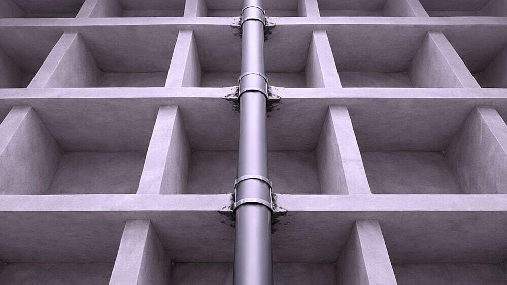 Darstellung Deckendurchbruch Schematische Darstellung eines Rohres, dass durch mehrere Geschossdecken nach oben geführt wird.