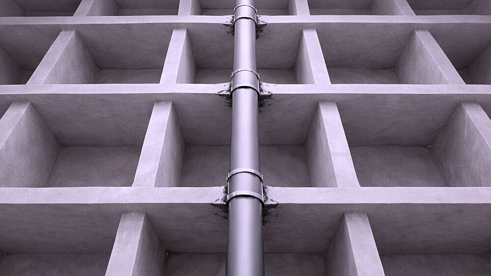 Darstellung Deckendurchbruch Schematische Darstellung eines Rohres, dass durch mehrere Geschossdecken nach oben geführt wird.